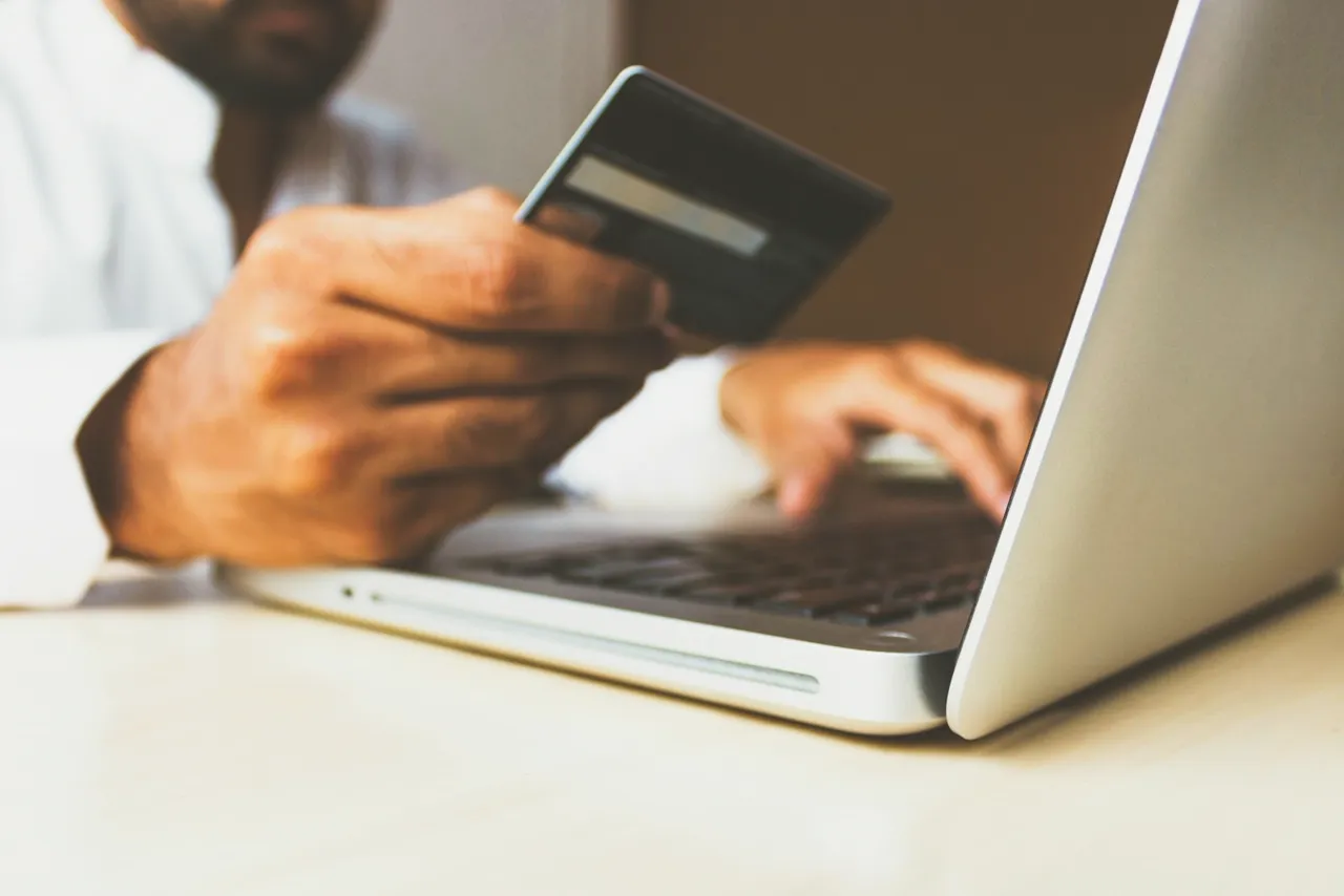 Cliente pagando con tarjeta en una tienda online desde su laptop
